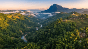 Aerial view of Mizoram's mountainous landscape featuring green hills, deep valleys, dense forests, rivers, and traditional Mizo villages.