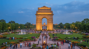 The iconic India Gate at Kartavya Path in New Delhi with landscaped gardens, Amar Jawan Jyoti, and Rashtrapati Bhavan in the background.
