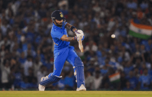 Virat Kohli playing a powerful straight drive during a T20 International match for India under stadium floodlights.